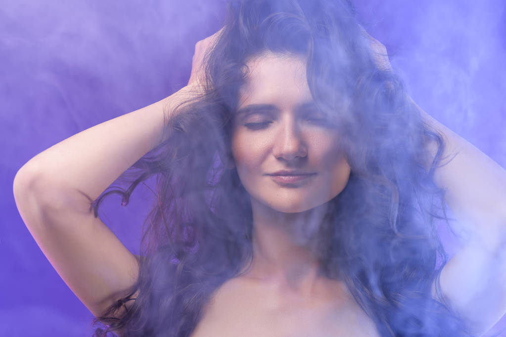 portrait of pretty naked girl with closed eyes in smoke on purple  - Photo, Image