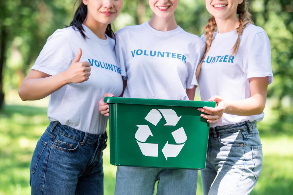 oříznutý pohled mladých dobrovolníků s zelená recyklace okno zobrazující palec  - Fotografie, Obrázek