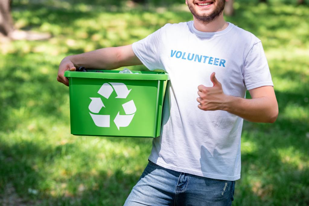 bijgesneden weergave van man met recycling vak en weergegeven: duim omhoog - Foto, afbeelding