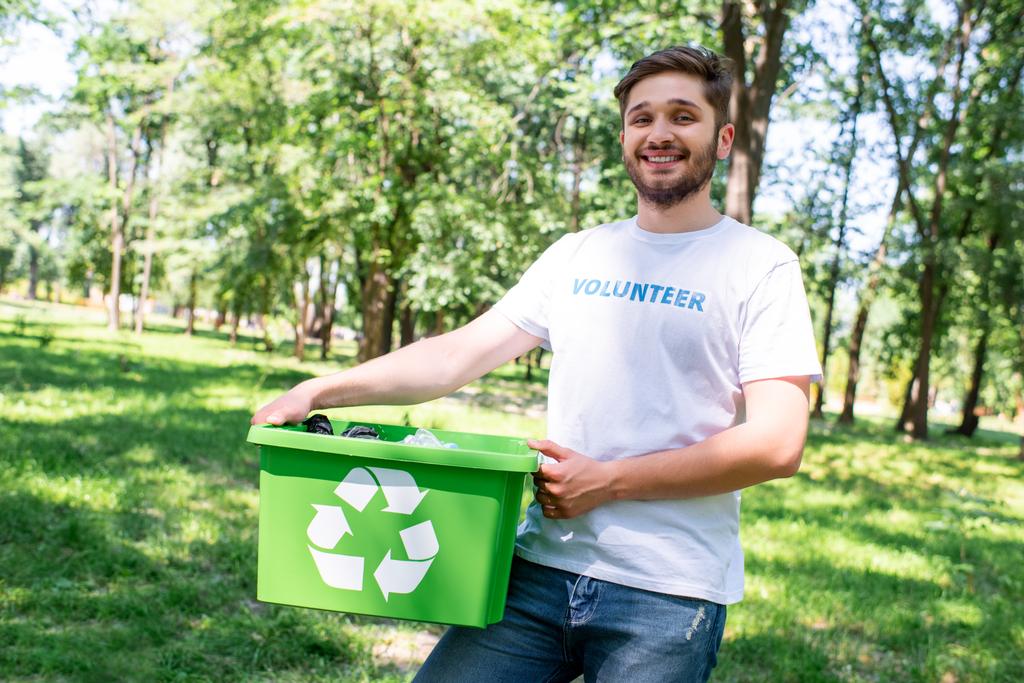 ευχαριστημένοι νέοι εθελοντές κρατώντας ανακύκλωσης κουτί με πλαστικό κάδο απορριμμάτων - Φωτογραφία, εικόνα