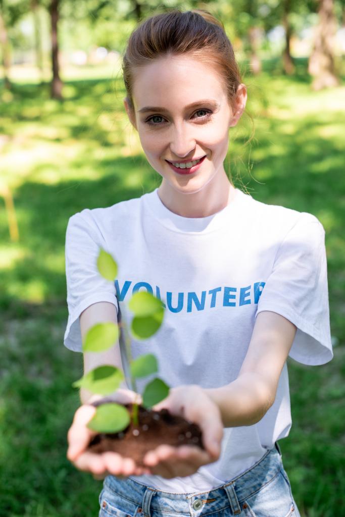 привлекательный улыбающийся волонтер, держащий новых в руках
 - Фото, изображение