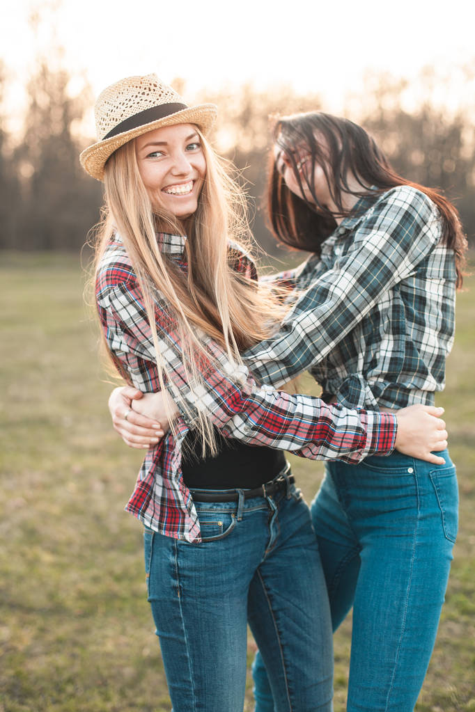 Дві веселі молоді жінки розважаються на полі. Найкращі друзі
 - Фото, зображення