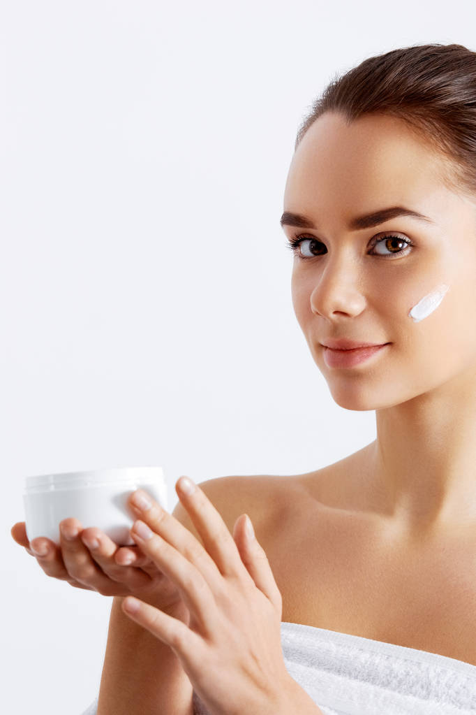 Hermosa mujer sosteniendo crema para la piel. Este es el mejor producto cosmético. Sostiene Loción Hidratante. Concepto de belleza
 - Foto, Imagen