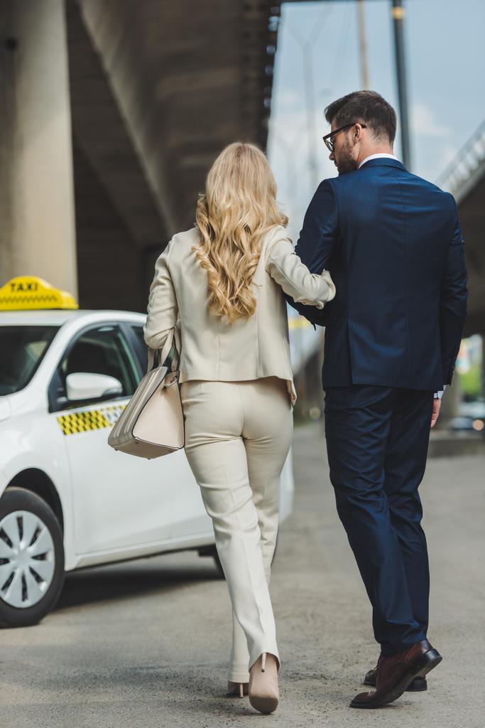 back view of stylish young couple going together to taxi cab - Photo, Image