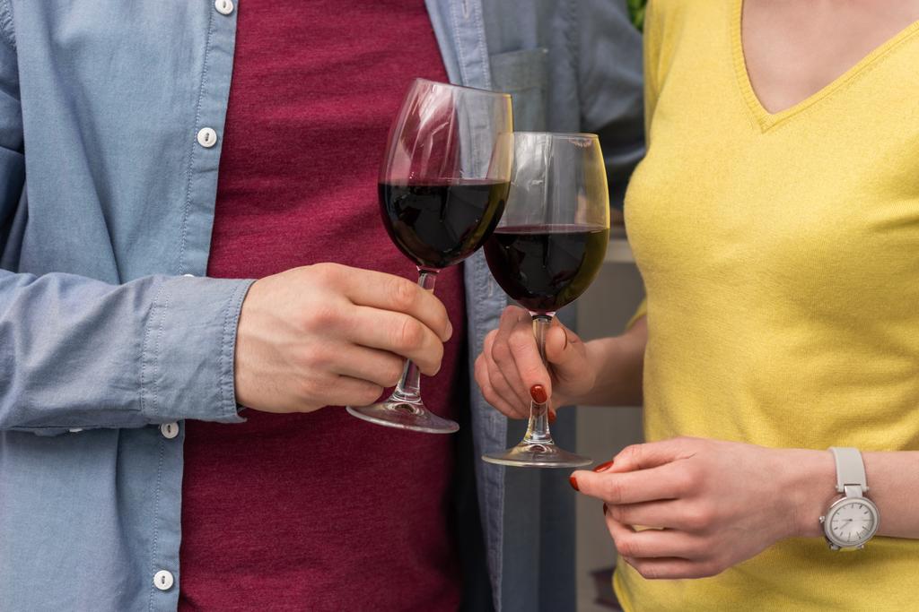tiro cortado de copos de vinho tinto casal clinking
 - Foto, Imagem