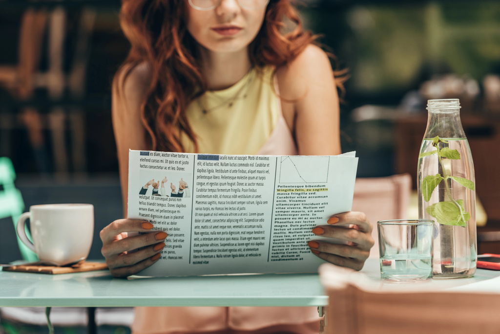 osittainen näkymä nainen lukee sanomalehteä kahvilassa
 - Valokuva, kuva