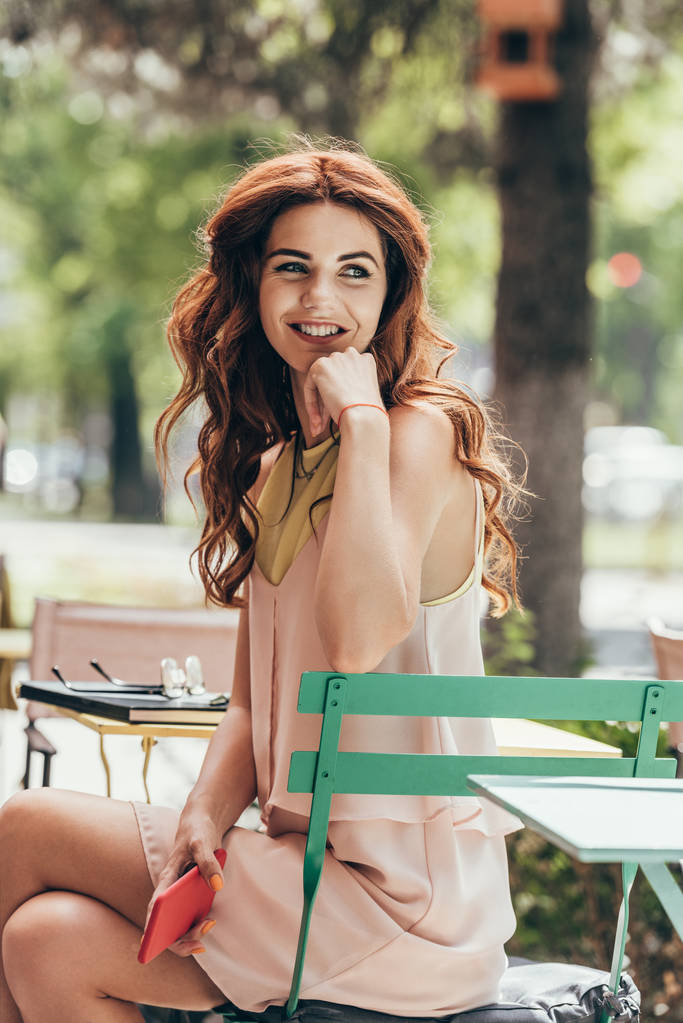молодая улыбающаяся деловая женщина сидит за столом с ноутбуком в кафе
 - Фото, изображение