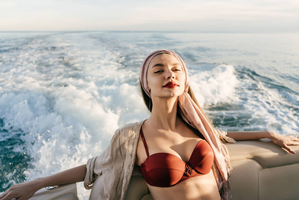 una donna ricca e lussuosa in costume da bagno gode di viaggi in mare e vacanze sul suo yacht bianco
 - Foto, immagini
