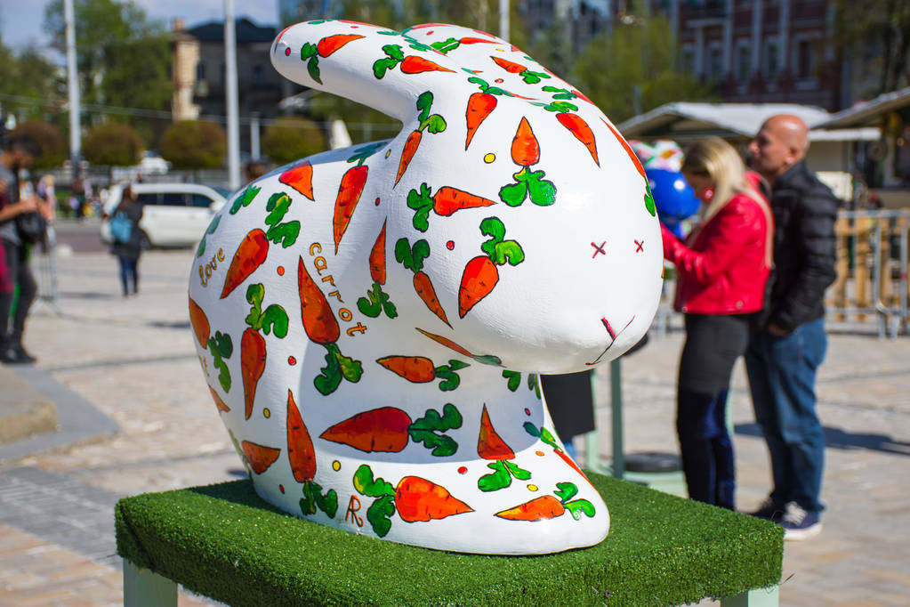 Figura de um coelho branco da Páscoa com cenouras pintadas de laranja e vermelho ao seu lado. Bela decoração de Páscoa arte
 - Foto, Imagem
