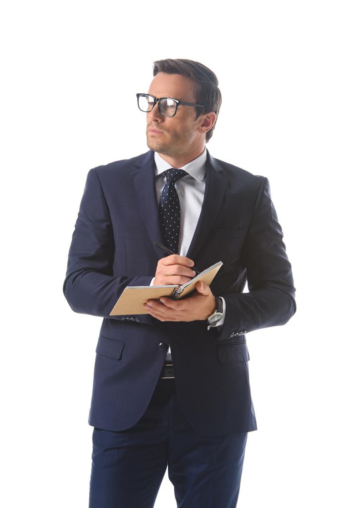 sérieux homme d'affaires dans les lunettes écriture dans le manuel isolé sur fond blanc
  - Photo, image
