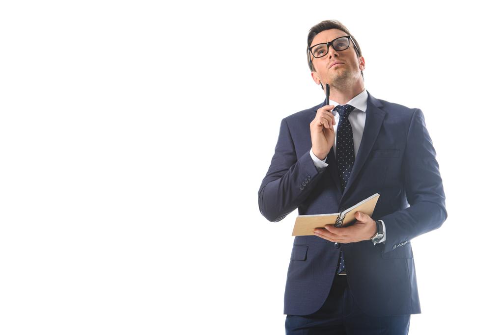 вдумливий бізнесмен в окулярах тримає ручку і підручник ізольовано на білому тлі
  - Фото, зображення