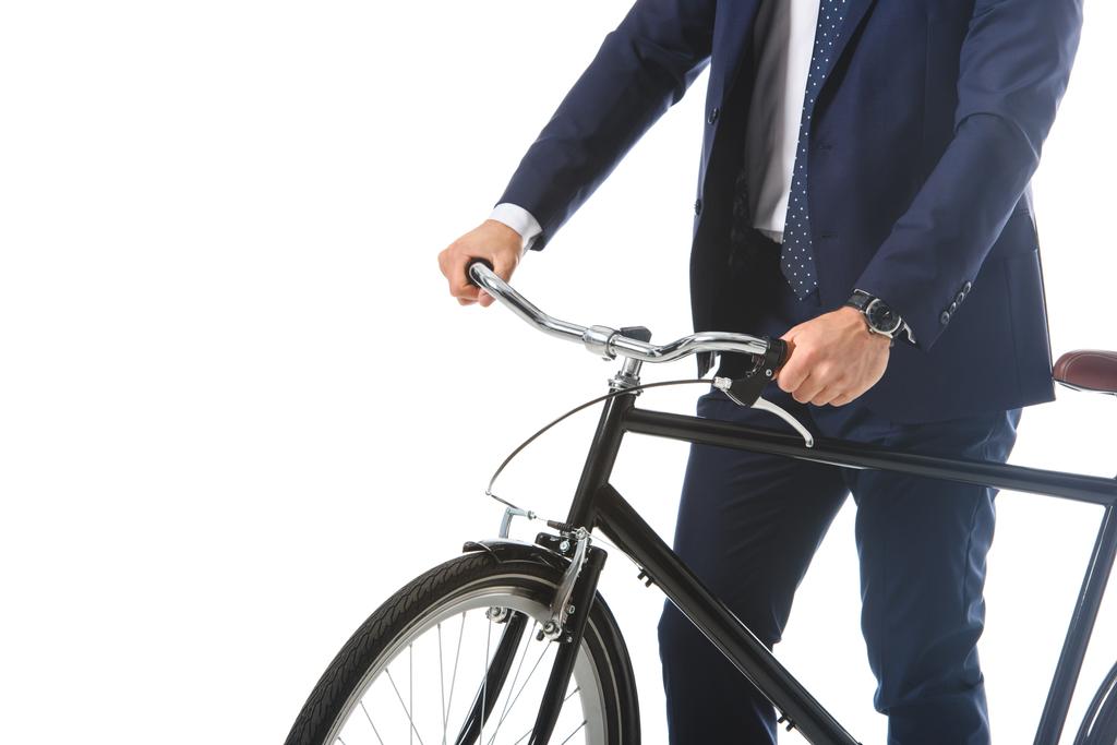 bijgesneden afbeelding van zakenman permanent met fiets geïsoleerd op witte achtergrond  - Foto, afbeelding