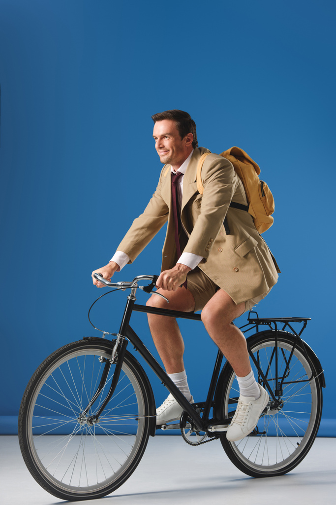 homme souriant en veste et short à vélo et regardant loin sur le bleu
 - Photo, image