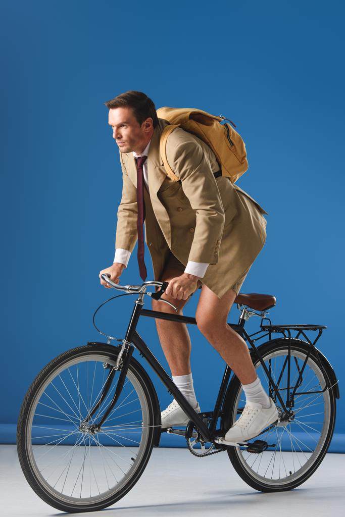 gerichte man met rugzak, fiets en weg op blauw - Foto, afbeelding