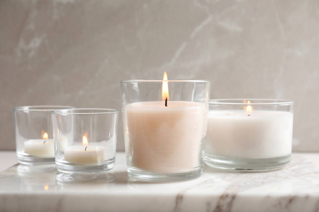 brennende Kerzen in Gläsern auf Marmorplatte - Foto, Bild