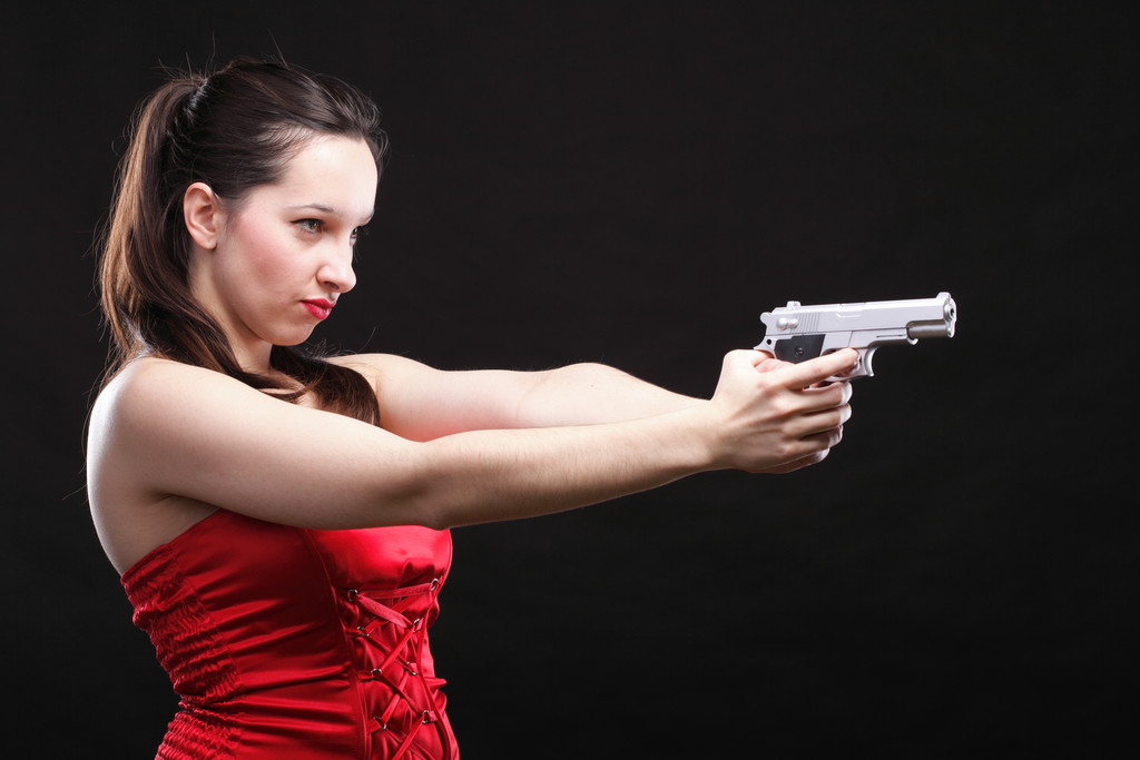 Szexi fiatal nő - gun fekete háttér - Fotó, kép
