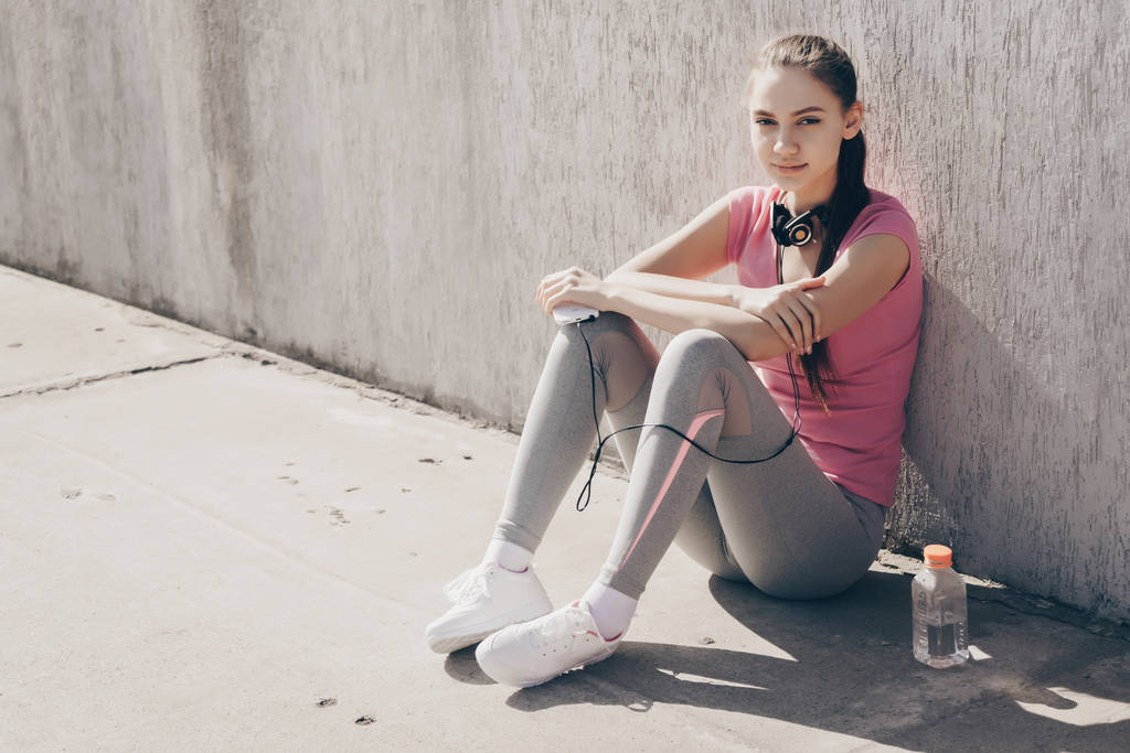 トレーニングと強さを増している後休んで屋外で、地面に座って自信を持ってスポーツ少女 - 写真・画像