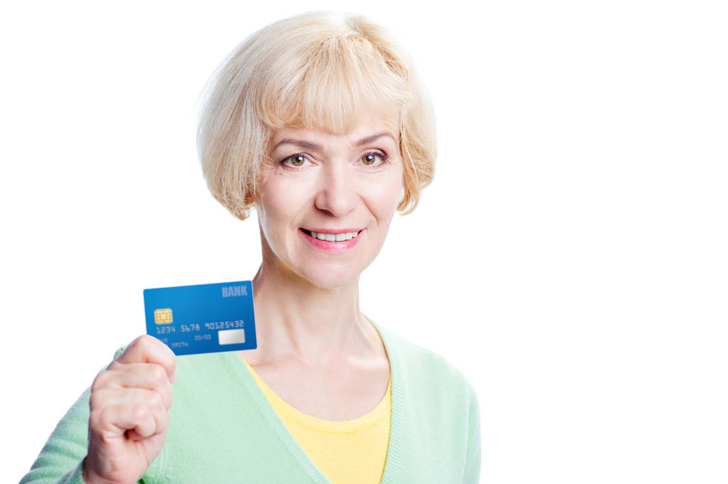 Ελκυστική μέσης ηλικίας γυναίκα δείχνει τραπεζική κάρτα - Φωτογραφία, εικόνα