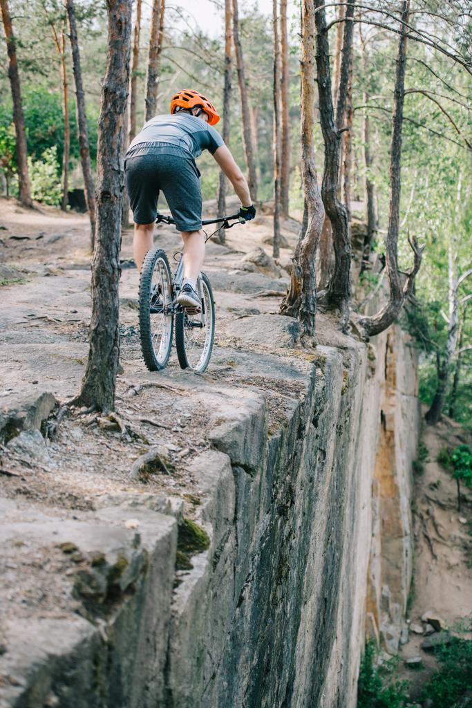 vélo de trial extrême chevauchant sur la falaise à la forêt
 - Photo, image