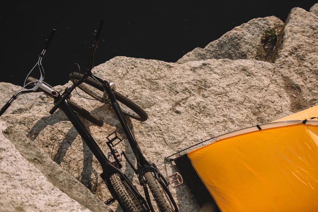 підвищений вид на гірські велосипеди та туристичний намет на скелястій скелі над річкою
  - Фото, зображення