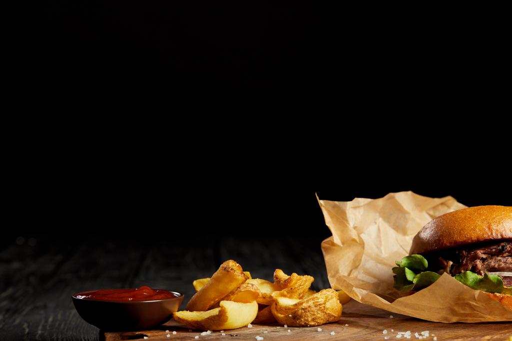 Заманчивая закусочная быстрого питания из гамбургера с картошкой и кетчупом на столе
 - Фото, изображение