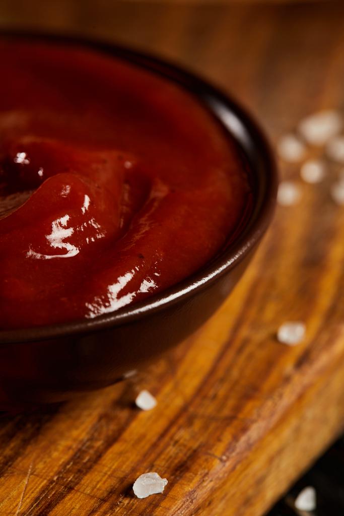 Ketchup em pires servidos em tábua de madeira com sal
 - Foto, Imagem