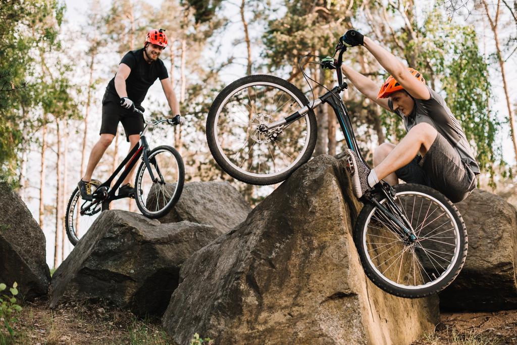 active young trial bikers riding on rocks outdoors - Photo, Image
