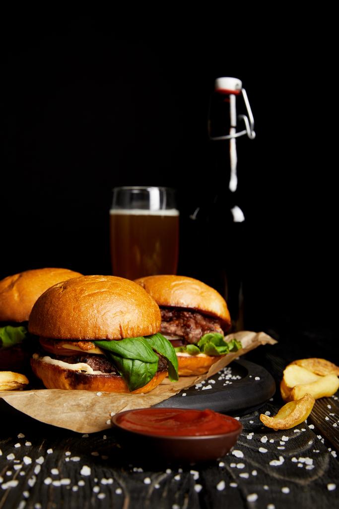 Set of junk food hamburgers on table with beer in bottle and glass - Photo, Image