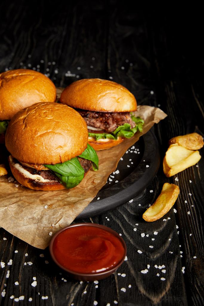 Lákavé rychlé občerstvení restaurace s hamburgery a brambory na dřevěný stůl - Fotografie, Obrázek