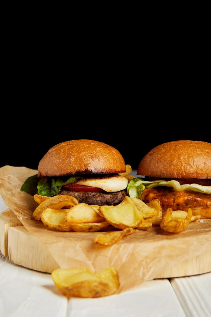 Set de comida chatarra con hamburguesas y papas fritas sobre mesa blanca
 - Foto, imagen