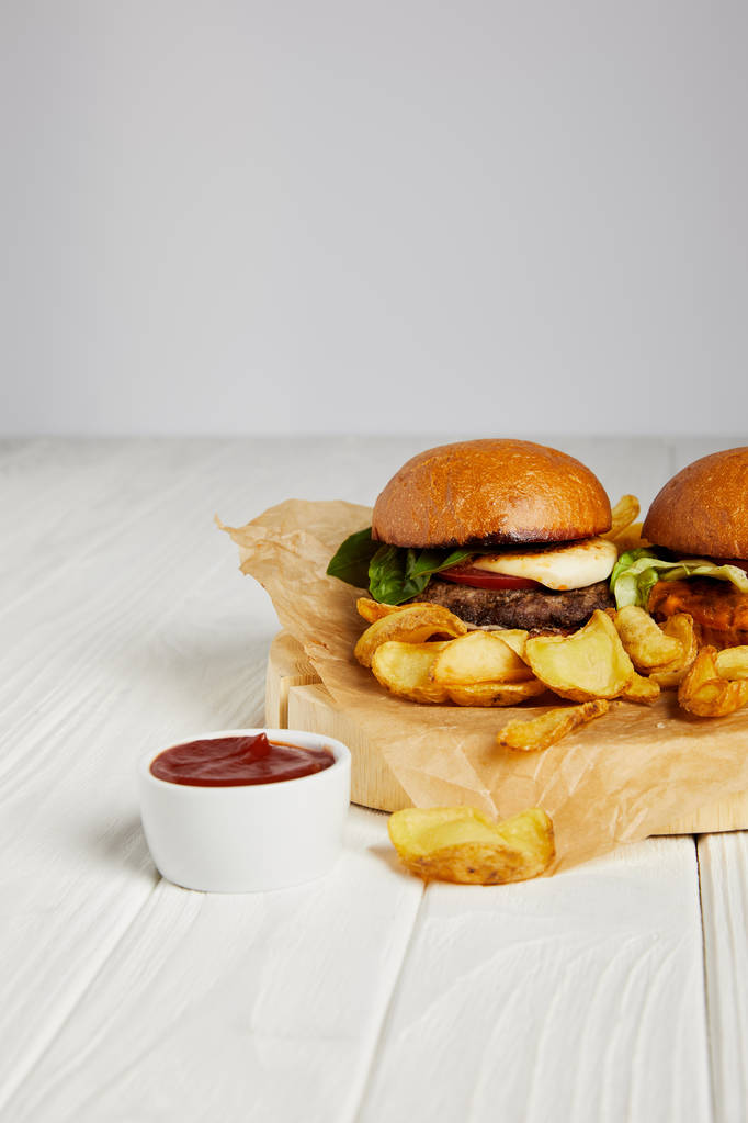 ファーストフードのハンバーガーと白いテーブルにケチャップ ダイナーを誘惑 - 写真・画像