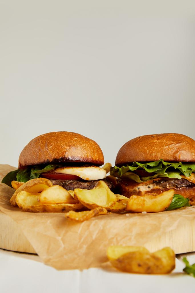 Hot hamburgers and french fries served on craft paper - Photo, Image