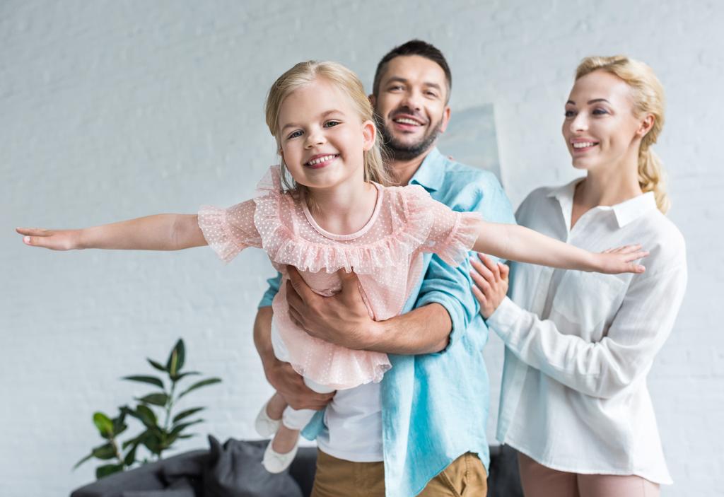 onnellinen perhe, jossa yksi lapsi pitää hauskaa yhdessä kotona
 - Valokuva, kuva