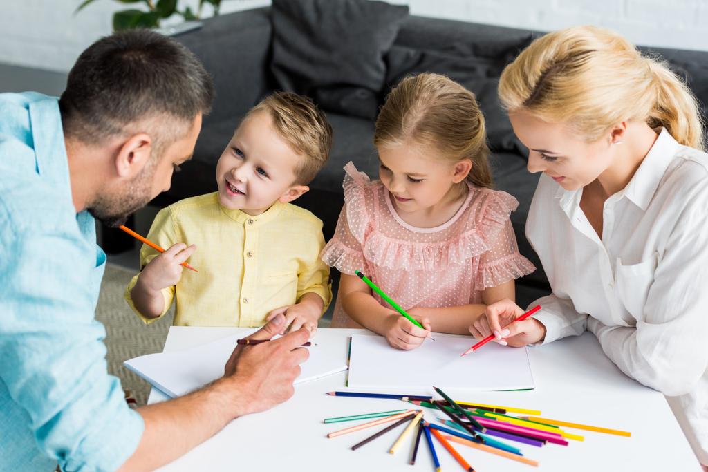 korkea kulma näkymä onnellinen vanhemmat söpö pikku lapset piirustus yhdessä kotona
  - Valokuva, kuva
