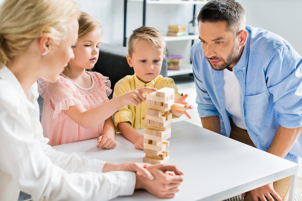 család, két gyermek játszó fadarabot otthon  - Fotó, kép