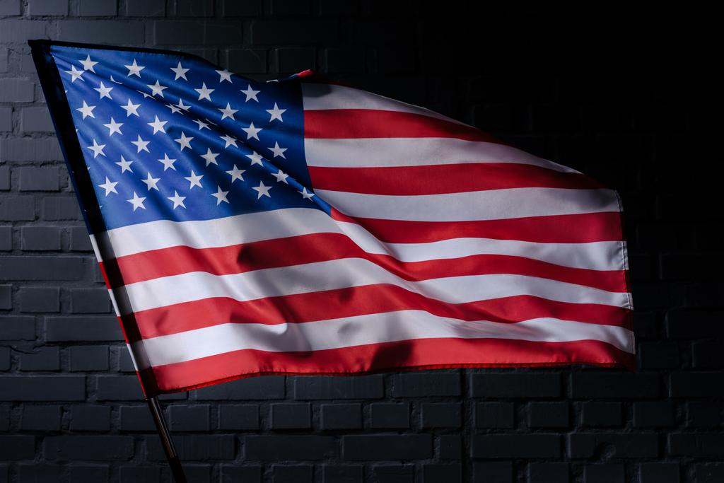 siyah tuğla duvar, bağımsızlık günü kavramı önünde ABD bayrak sallayarak - Fotoğraf, Görsel