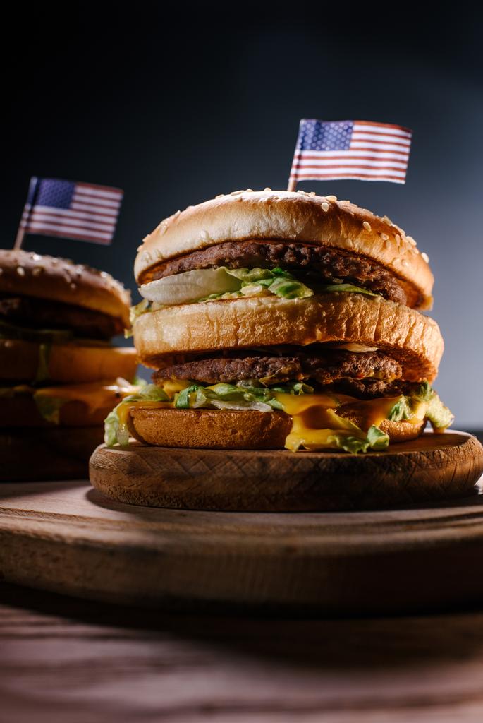 Siyah ahşap kesme tahtası üzerinde ABD bayrağı ile lezzetli hamburger yakın çekim çekim pimleri - Fotoğraf, Görsel