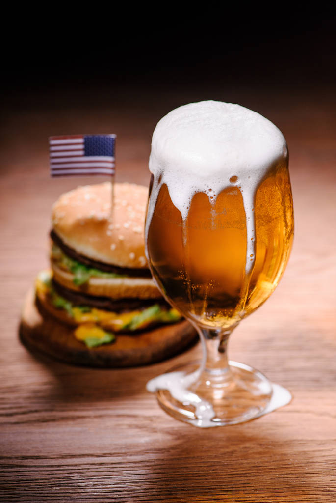 tasty burger with glass of beer on wooden table - Photo, Image