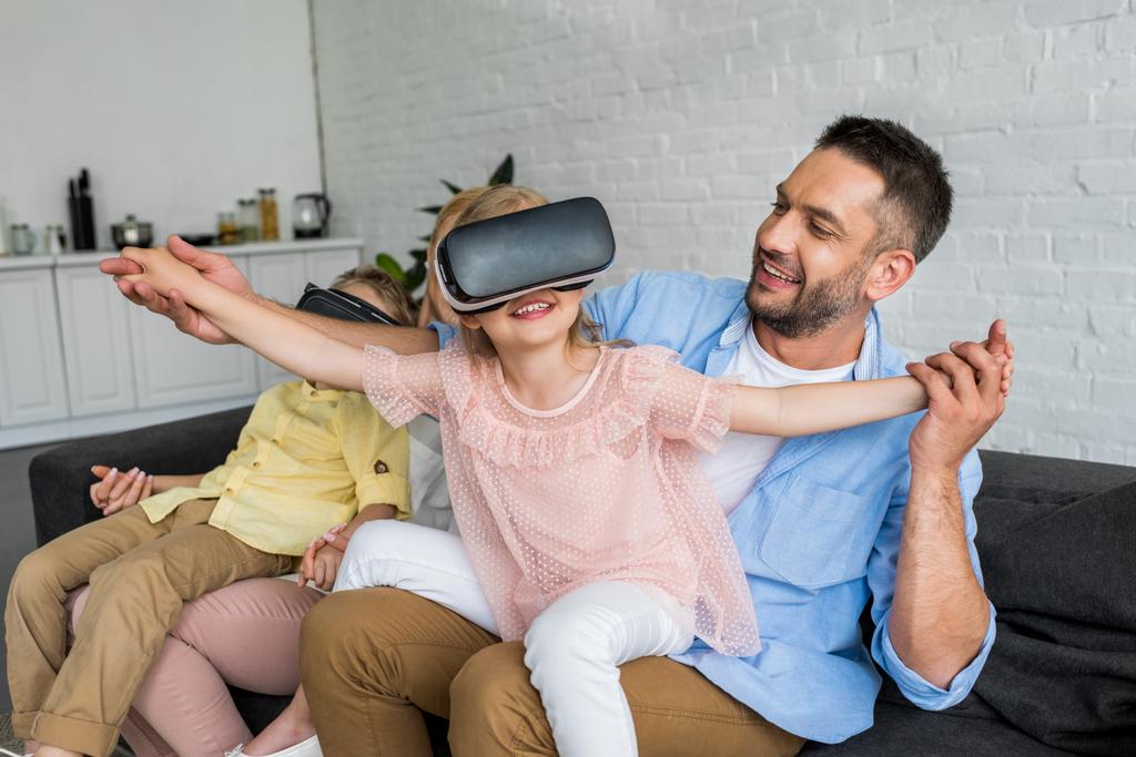 šťastní rodiče, kteří hrají s dětmi doma pomocí virtuální reality sluchátka - Fotografie, Obrázek