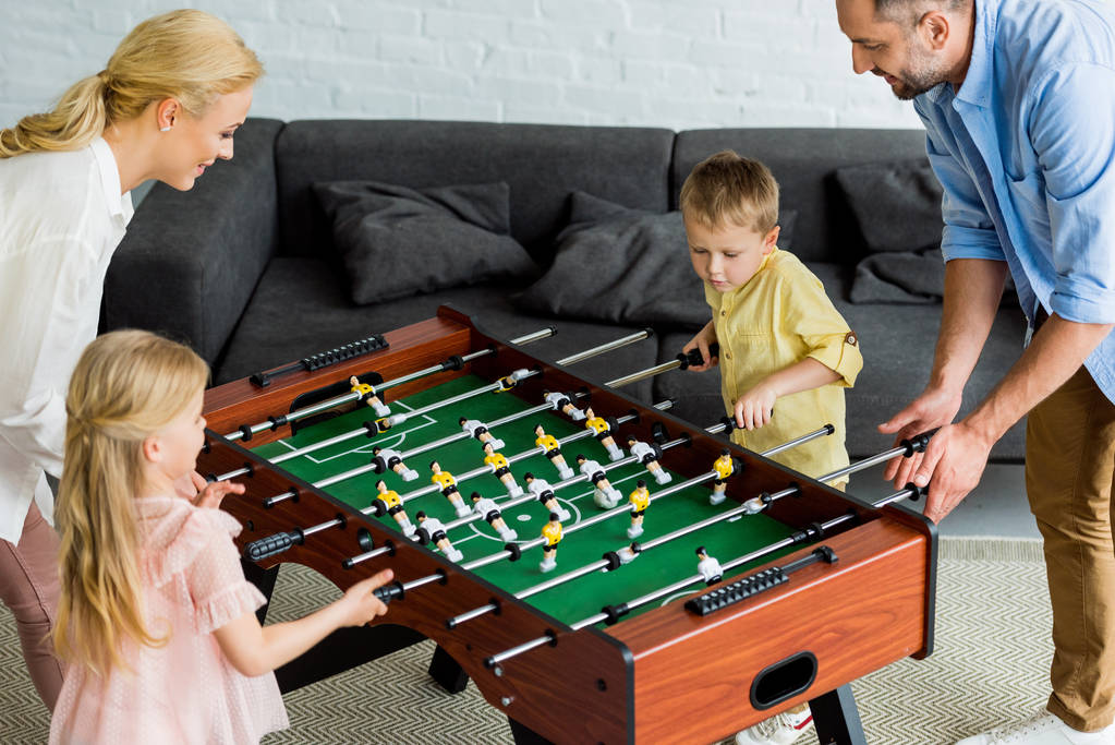 テーブル サッカーを家で一緒に遊ぶ 2 人の子供と幸せな家庭のハイアングル  - 写真・画像