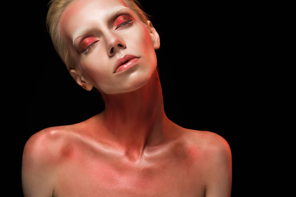 красивая обнаженная модная девушка позирует с красным телом и закрытыми глазами, изолированными от черного
 - Фото, изображение