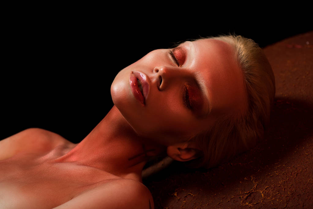 attraktive Frau mit geschlossenen Augen und rotem Body Art posiert für Mode-Shooting auf schwarz - Foto, Bild