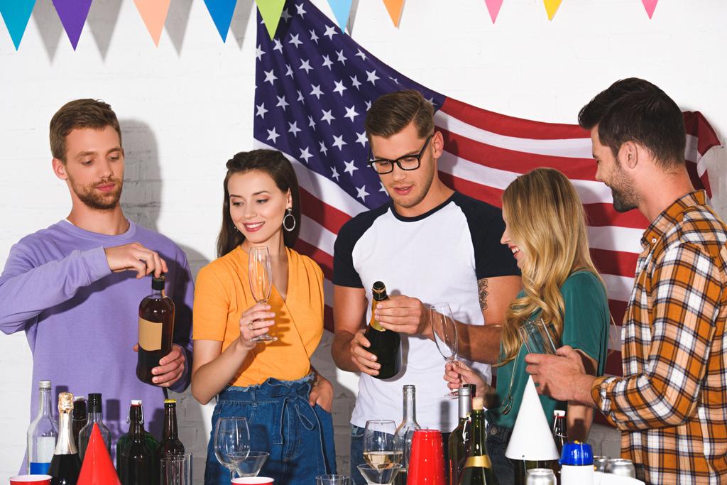 heureux jeunes hommes et femmes amis boire des boissons alcoolisées à la fête à la maison
  - Photo, image