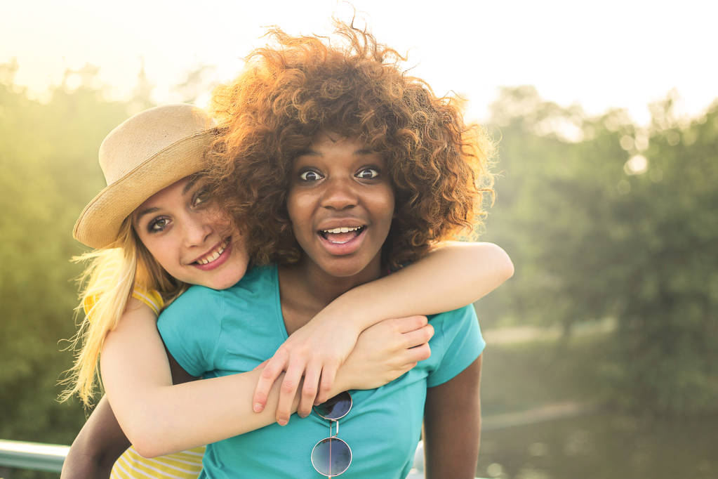 2 つの若い女性の友人は通りに楽しんで、夏の日に自分自身を楽しんで. - 写真・画像