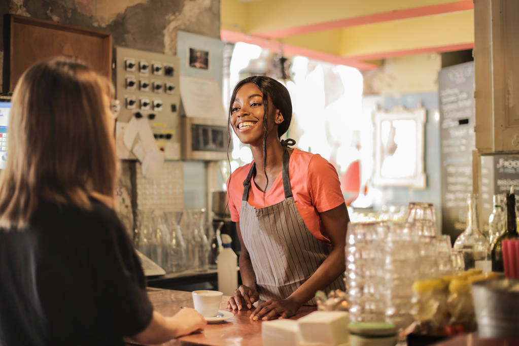 Młody piękny Afro kelnerka pracująca w bistro. - Zdjęcie, obraz