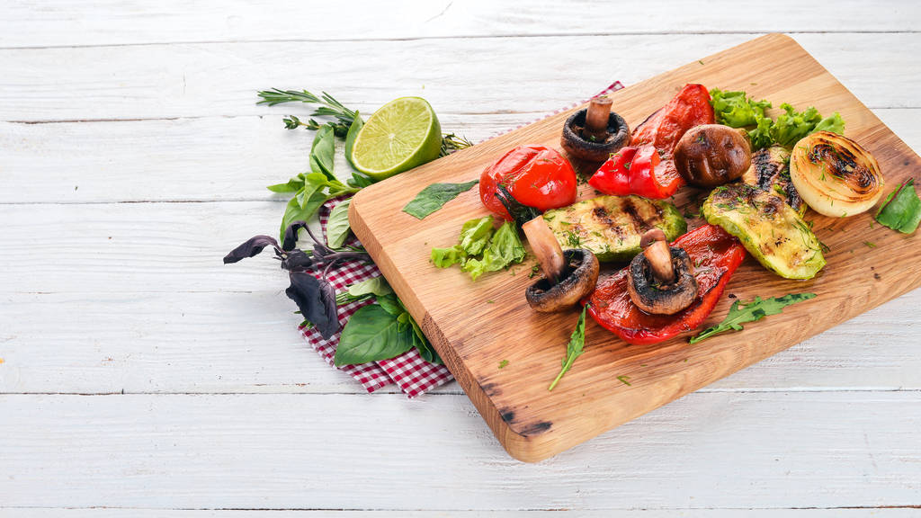 Grilled vegetables on a wooden board. On a wooden background. Top view. Copy space. - Photo, Image