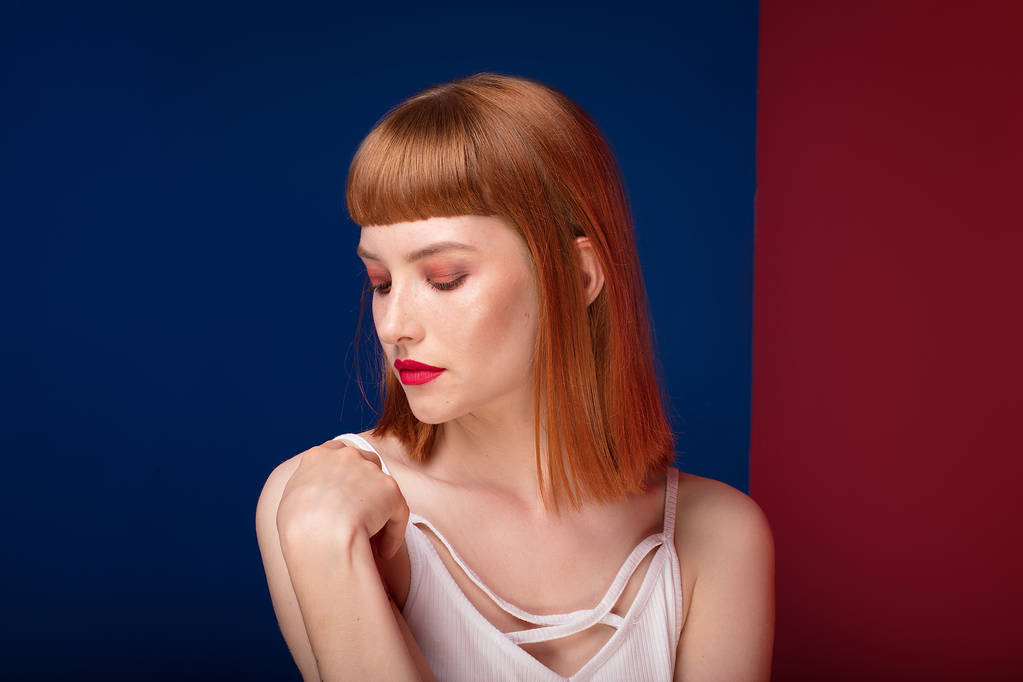 Porträt einer schönen rothaarigen jungen Frau. Mädchen in Glamour-Make-up. Haarschnitt mit Fransen. - Foto, Bild