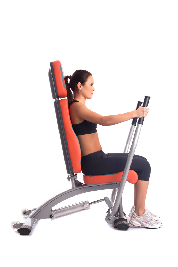 Brunette young woman on hydraulic exerciser - Photo, Image