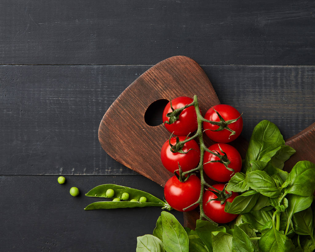 healthy raw vegetables on wooden table, tomatoes, peas and basil leaves as food background  - Photo, Image