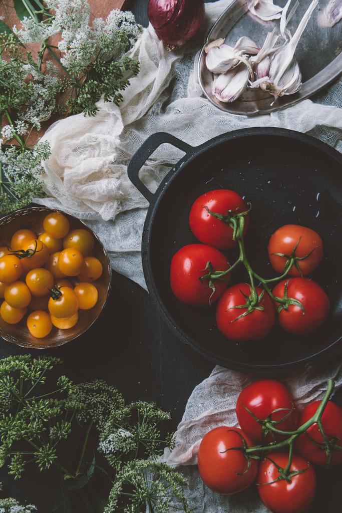 вид зверху на жовті вишневі помідори та червоні помідори в сковороді на марлі на дерев'яному фоні з квітами петрушки
 - Фото, зображення